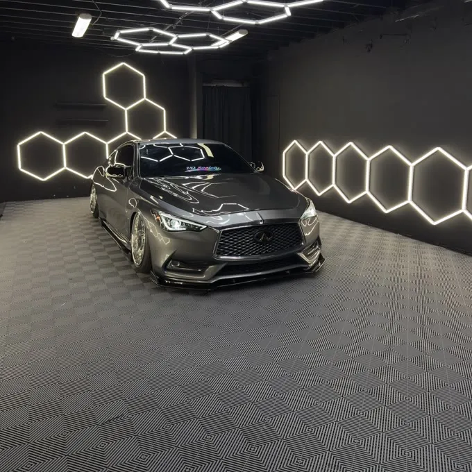 Infiniti Q60 under the shop lights after detailing